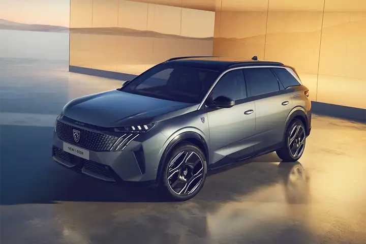 Front view of the Peugeot e‑5008 electric SUV, showing bold LED matrix headlights, aerodynamic grille design, and updated bumper styling with 400 V architecture and fast‑charging capability up to 160 kW.