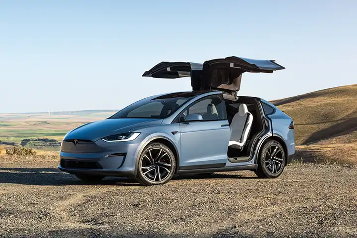 Front view of the Tesla Model X electric SUV with aerodynamic nose, LED headlights, and large windshield, showcasing dual-motor AWD and 800V charging.